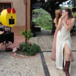 fotomaton con cara de emoji y chicas posando delante para hacerse fotos